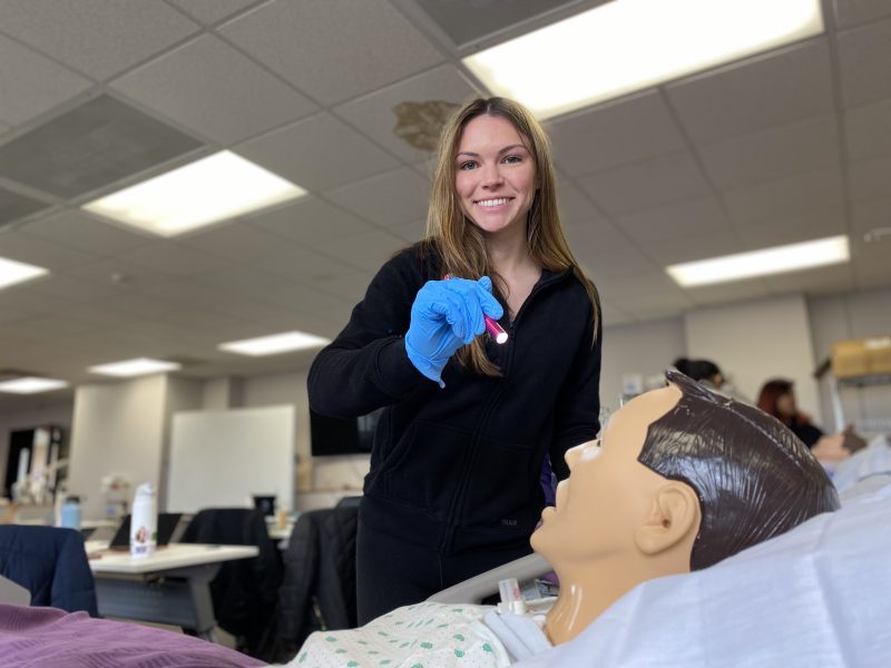 female nursing student in sim lab