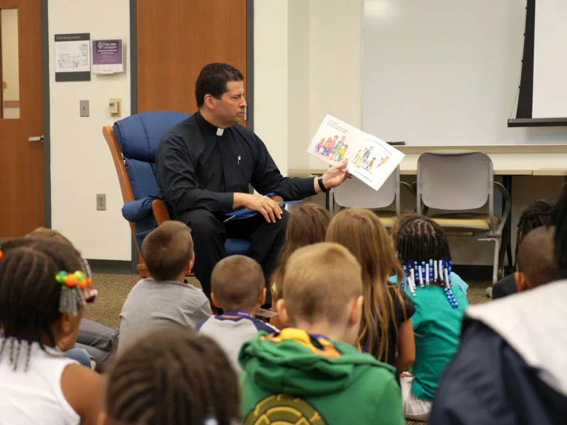Father Maher reading to children