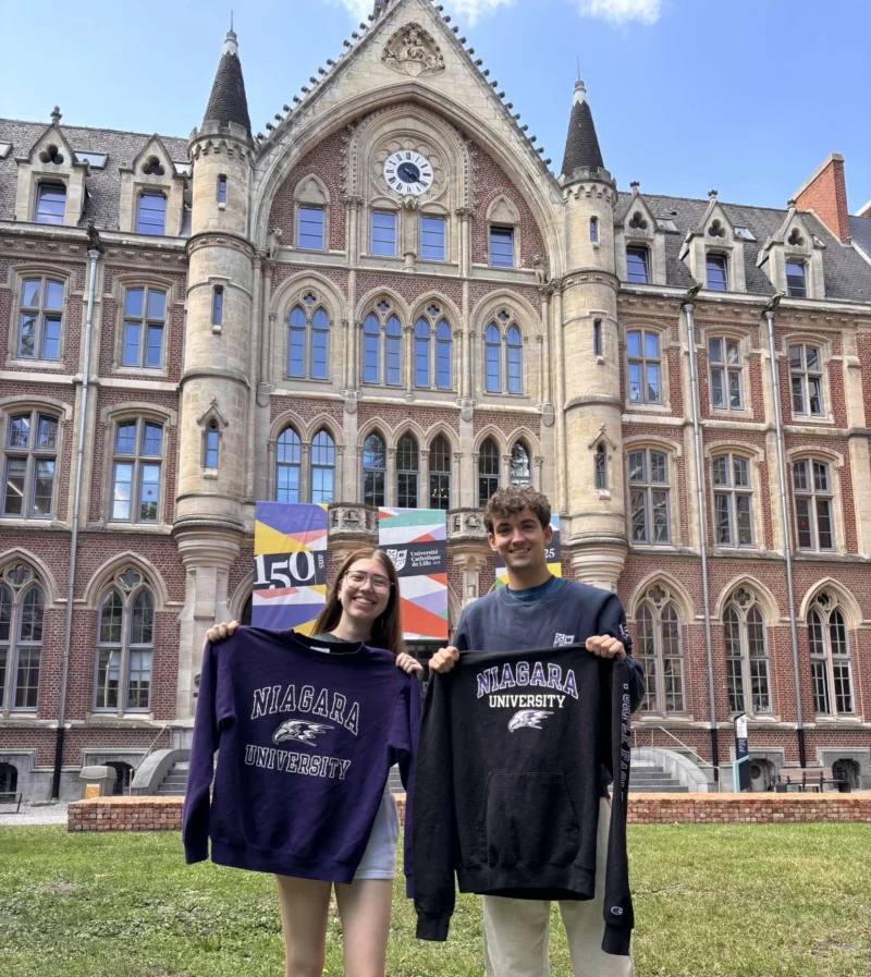 Students holding NU sweatshirts