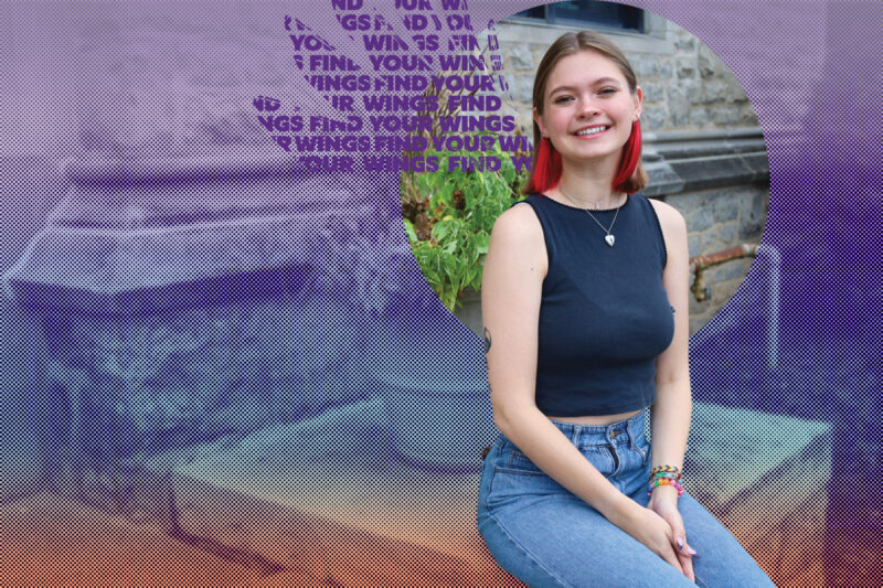 NU Student smiles on the front steps of Gacioch Hall.