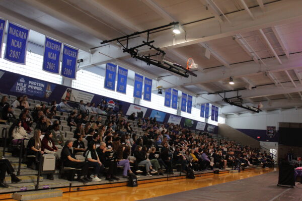 Students standing behind a table that contains stickers, suckers and pamphlets