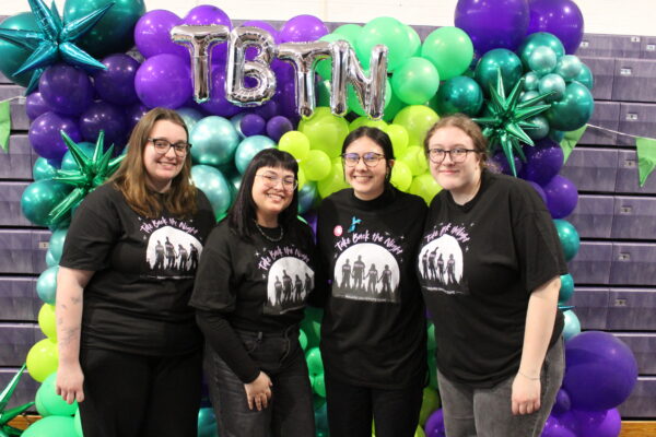 Four Students standing in front of balloons
