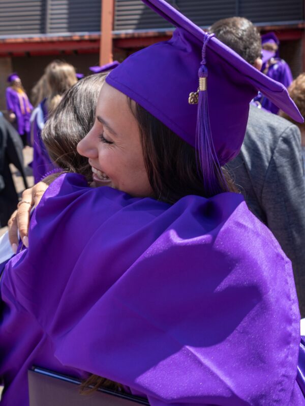 Female NU graduate hugging a friend