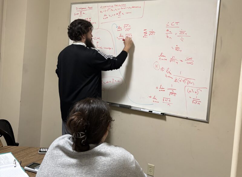 math tutor writing a math equation on the whiteboard